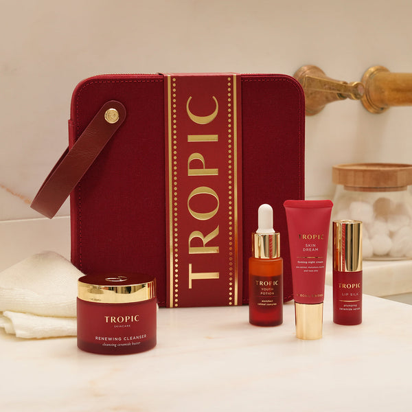 The Ultimate Renew Facial - targeted rejuvenation collection by Tropic. A luxurious red gift set case with four skincare products displayed in front: Renewing Cleanser, Youth Potion serum, Skin Dream night cream, and Lip Silk treatment.