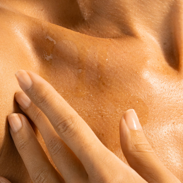Close-up of model’s skin with Tropic Luxury Body Oil applied, showing a smooth, radiant finish.