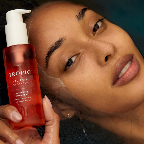 This image features a person holding a bottle of Radiance Cleanser, a pore-refining cleansing oil. The product is highlighted as being rich in Vitamin C, azelaic acid, and dragon fruit oil. The individual’s glowing, smooth complexion emphasises the cleanser’s ability to deeply cleanse and refine pores, leaving the skin radiant and refreshed.
