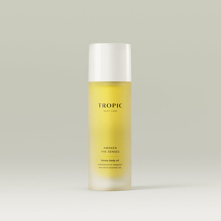 Tropic Awaken The Senses luxury body oil with macadamia oil, bergamot, and neroli essential oils in a sleek frosted bottle.