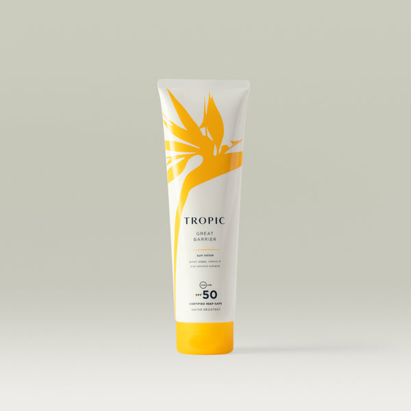 A white tube of Tropic Great Barrier Sun Lotion with SPF 50, showcasing a yellow tropical leaf design and text highlighting 'certified reef-safe' and 'water resistant'.