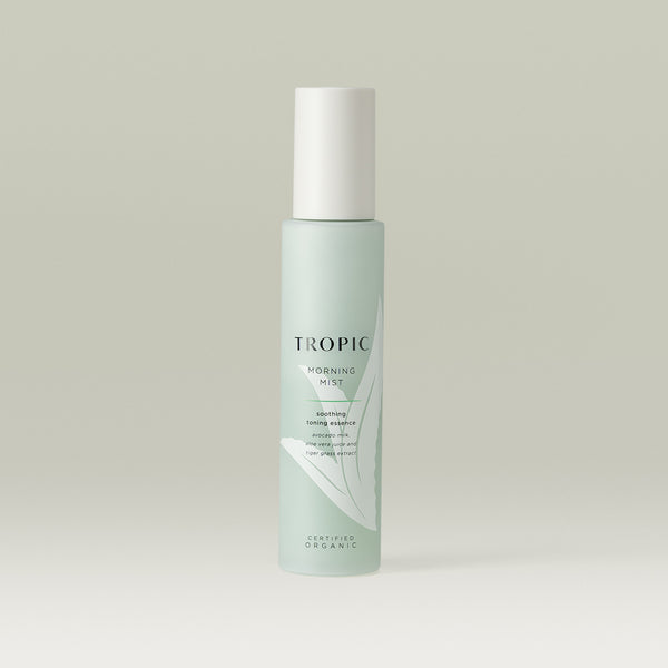 Tropic Morning Mist soothing toning essence. Contains avocado milk, aloe vera juice and tiger grass extract. Certified Organic.
Glass light green bottle with white lid.  Aloe vera plant design features behind black text.