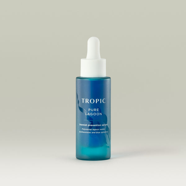 Tropic Pure Lagoon blemish prevention serum. Contains Polynesian lagoon water, bioflavonoids and blue spirulina. 
White pipette dispenser and Bright blue glass bottle with wavy embossed design behind the white text.