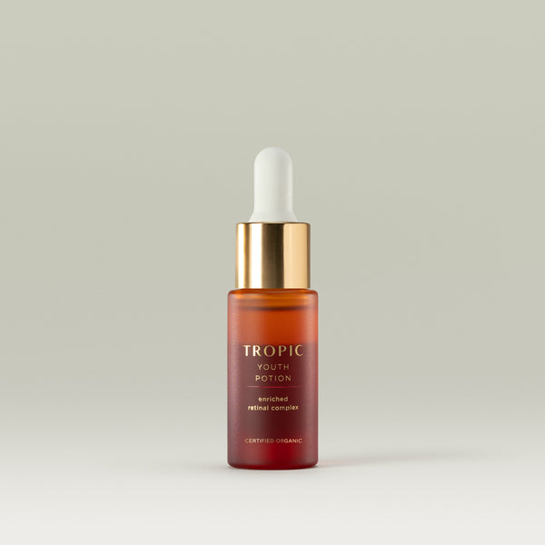 10ml bottle of Tropic Youth Potion enriched retinal complex, with a gold cap and dropper, displayed on a neutral background.