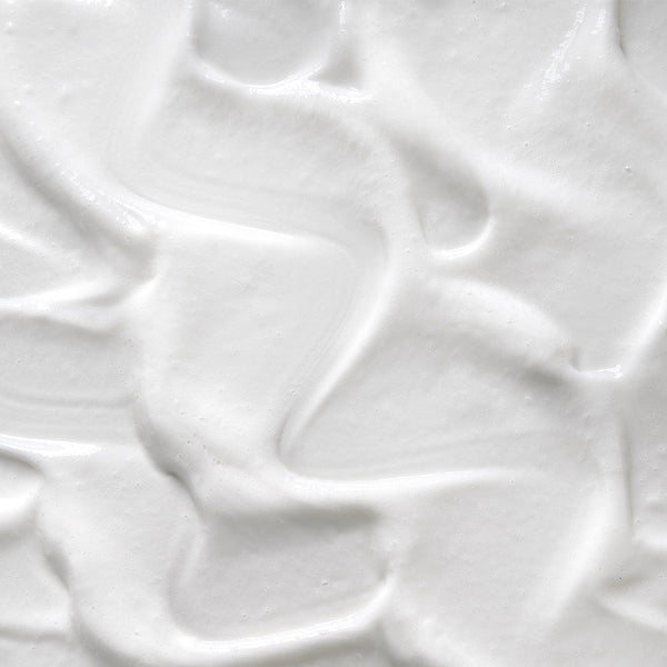 Close-up texture of creamy white Tropic body wash with a smooth, whipped consistency.