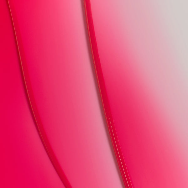 Macro texture of Tropic Lip Fudge in shade Pink Guava, showing smooth, glossy swirls of the vibrant tinted lip formula.