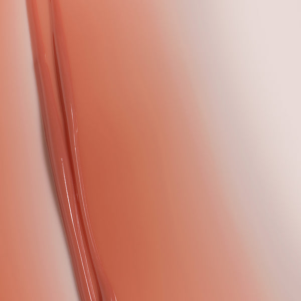 Macro texture of Tropic Lip Fudge in shade Rosewood, showing smooth, glossy swirls of the tinted lip formula.