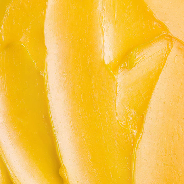 Macro texture of Tropic Lip Love nourishing balm, showing smooth, rich yellow balm for soft and hydrated lips.