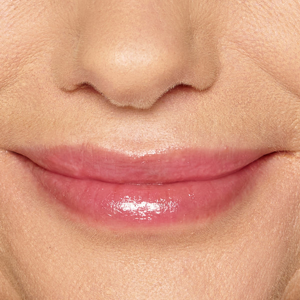 Close-up of model’s lips wearing Tropic Lip Fudge in shade Pink Guava, giving a glossy, tinted finish.