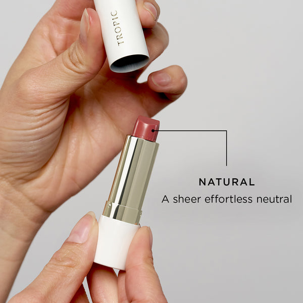 Butter Tint being held with lid above, labeled 'Natural' on a gray background