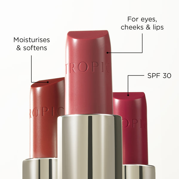 Three tubes of Tropic multi-purpose butter tint. Text annotations highlight features: 'Moisturises & softens,' 'For eyes, cheeks & lips,' and 'SPF 30.' The word 'TROPIC' is embossed on each bullet.