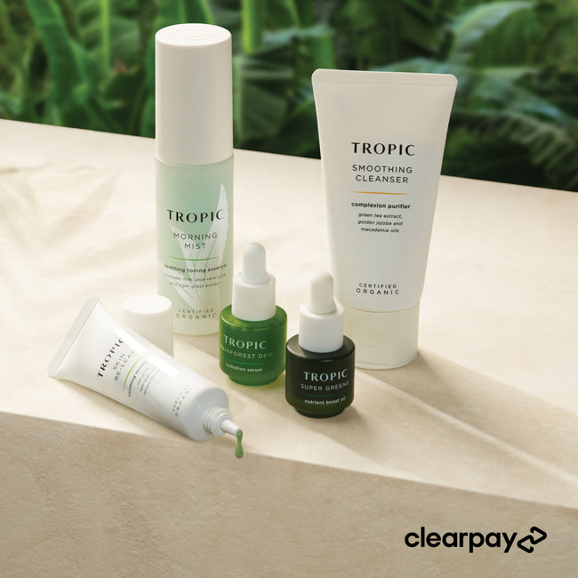 Tropic mini skincare products on a beige surface with a green leafy background
