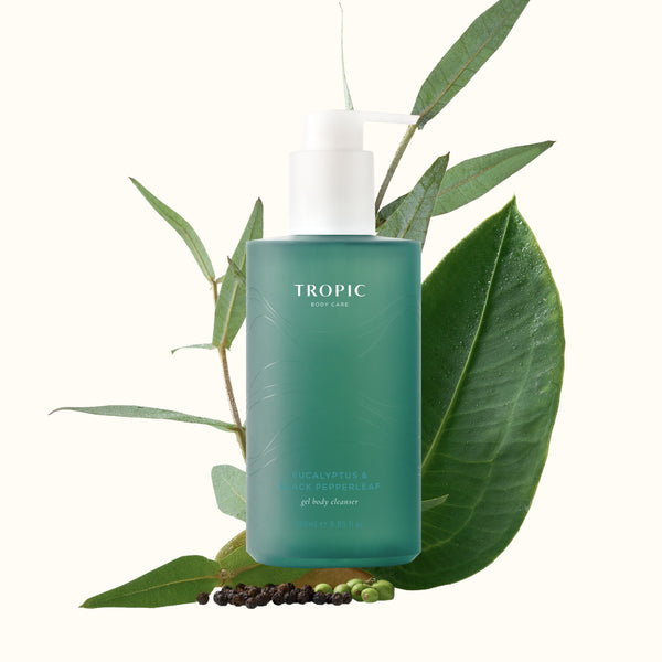Eucalyptus & Black Pepperleaf Gel Body Cleanser surrounded by eucalyptus leaves and peppercorns.