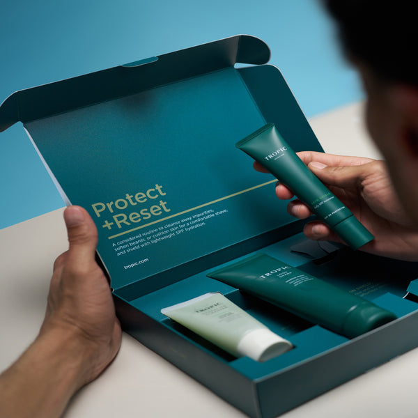 Person holding a skincare product with a 'Protect & Reset' box in the background.
