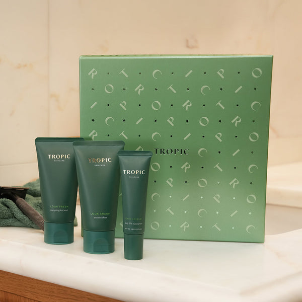 The Wakeup Call - energising skincare essentials collection by Tropic. A green gift set box with three matching green skincare tubes displayed in front: Look Fresh energising face wash, Look Sharp sensitive shave, and Skin Shield daily SPF moisturiser.