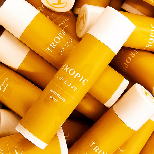This image showcases a collection of Tropic Lip Love nourishing balms. The vibrant yellow packaging emphasises the product's cheerful, hydrating, and soothing properties. These balms are designed to provide deep moisture and nourishment for soft, smooth lips, reflecting Tropic's commitment to natural and effective skincare.