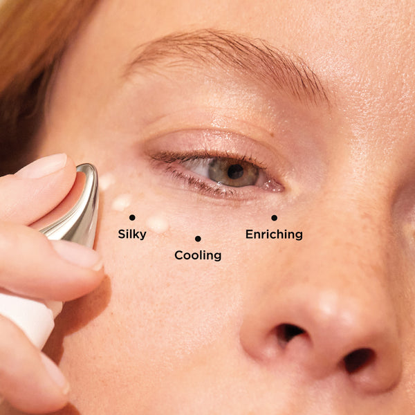 Image show a woman applying Eye Work under her eyes by dotting it on the skin. It is silky, cooling and enriching.
