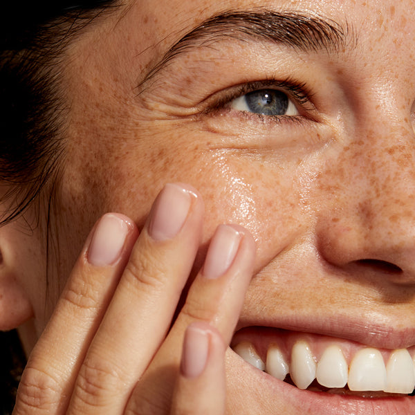 This image features a close-up of a smiling person gently massaging Youth Potion onto their cheek. The skin looks radiant, hydrated, and visibly plump, emphasising the product's benefits, such as reducing fine lines, improving skin elasticity, and promoting a youthful glow.