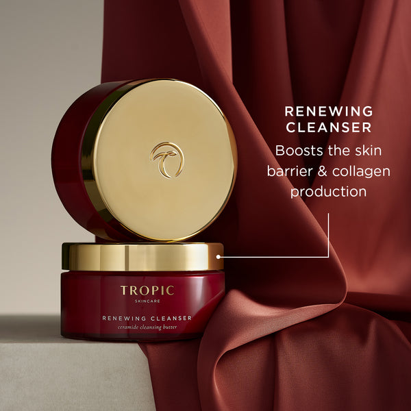 Tropic Renewing Cleanser in a red jar with a gold lid, styled on rich red fabric. On image copy reads: “Renewing Cleanser – boosts the skin barrier & collagen production”.