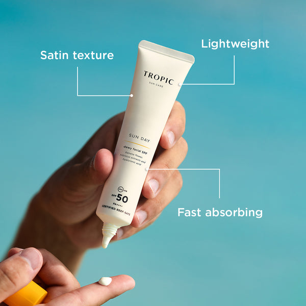 Tropic Sun Care Sun Day dewy facial SPF 50: has a satin texture, is  lightweight and is fast absorbing. Model holds the product in their hands applying to their finger.