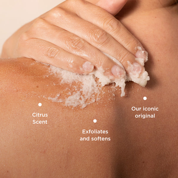The image shows Tropic Body Smooth Refreshing Polish being applied to the shoulder, highlighting its exfoliating texture. Key product benefits are labeled:

Citrus Scent, offering a refreshing fragrance.
Exfoliates and softens, gently removing dead skin cells for smooth, soft skin.
Our iconic original, emphasizing its status as a classic, well-loved product.
The rich scrub and its application suggest a luxurious, spa-like skincare experience.