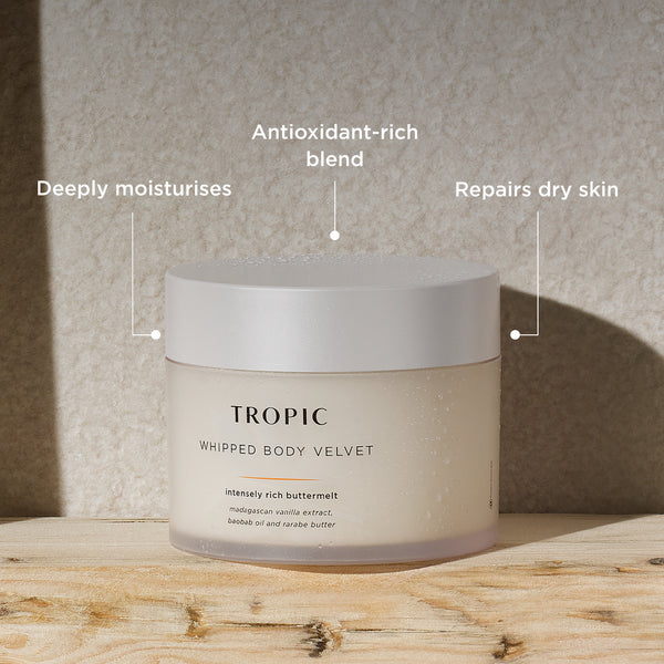 The image showcases a jar of Tropic Whipped Body Velvet, set against a natural, textured background. Key benefits are highlighted:

Deeply moisturises, providing intense hydration for dry skin.
Antioxidant-rich blend, featuring nourishing ingredients like Madagascan vanilla extract, baobab oil, and rarabe butter to protect and rejuvenate the skin.
Repairs dry skin, helping to restore and smooth rough or damaged areas.