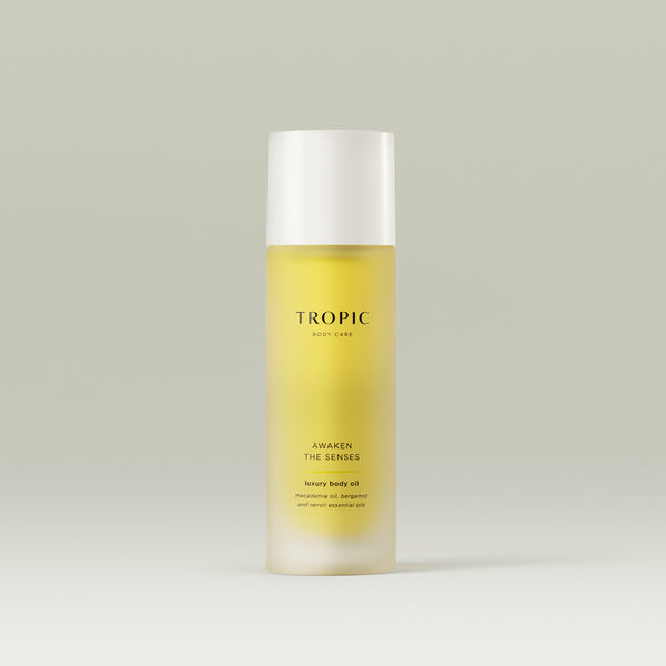 Tropic Awaken The Senses luxury body oil with macadamia oil, bergamot, and neroli essential oils in a sleek frosted bottle.