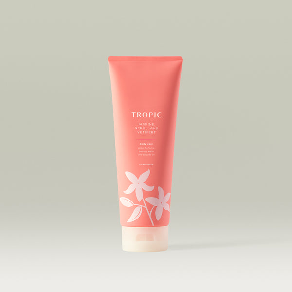 Tropic Jasmine, Neroli and Vetivert Body Wash in a coral pink tube with floral design.