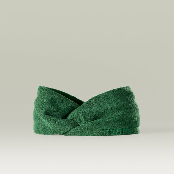 Green bamboo fabric headband with a twisted knot design, displayed against a neutral background.