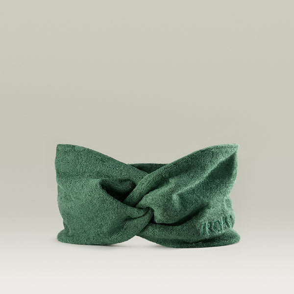 Green bamboo fabric headband with a twisted knot design, displayed against a neutral background.