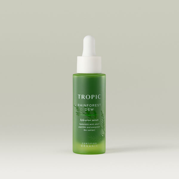 Tropic Rainforest Dew hydration serum. Contains hyaluronic acid, plant peptides and evergreen fern extract. Certified Organic. 
White pipette dispenser on a green glass bottle. Embossed leaf design behind white text.