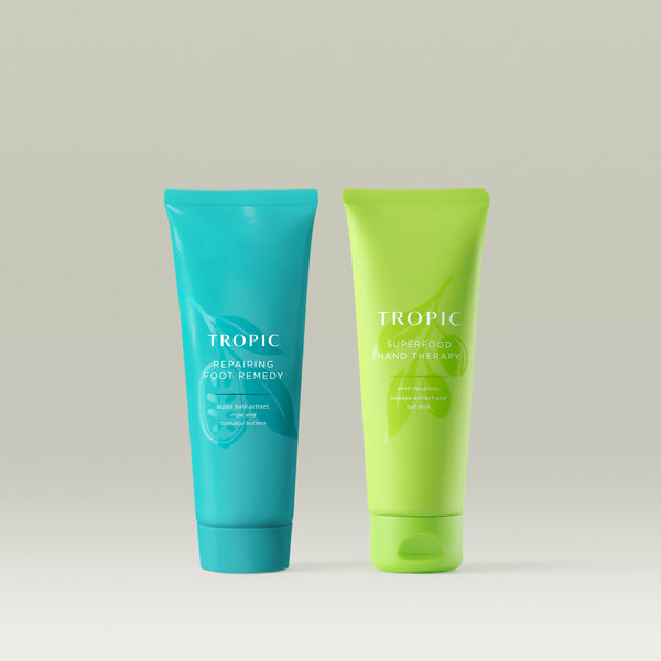 Two Tropic skincare products, Repairing foot remedy and superfood hand therapy on a light gray background.
