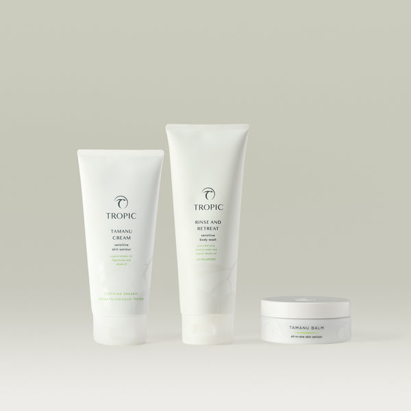 The Tamanu Trio contains Tamanu Cream, Rinse and Retreat and Tamanu balm on a gray background.