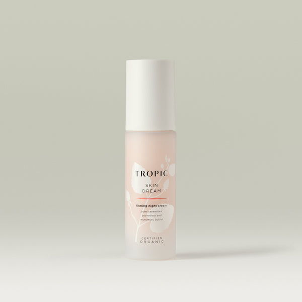 Tropic Skin Dream firming night cream in a frosted pink bottle with white cap, featuring minimalist floral design.