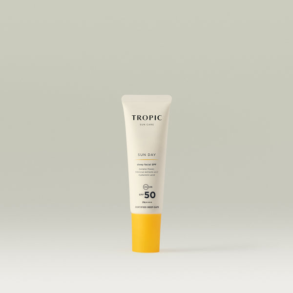 Tropic Sun Day mini dewy facial SPF 50 sunscreen 15ml in a slim white tube with bright yellow cap, displayed against a soft neutral background.