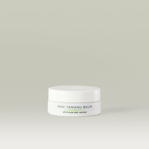 Mini Tamanu Balm all-in-one skin saviour. 
White round tub with Tropic logo on the lid and faint white leaf design on the bottom of the tub.