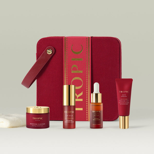Tropic Skincare gift set titled The Ultimate Renew Facial – targeted rejuvenation collection, featuring the Renewing Cleanser, Lip Silk serum, Youth Potion, and Skin Dream moisturiser, displayed in front of a luxurious red case with gold accents.