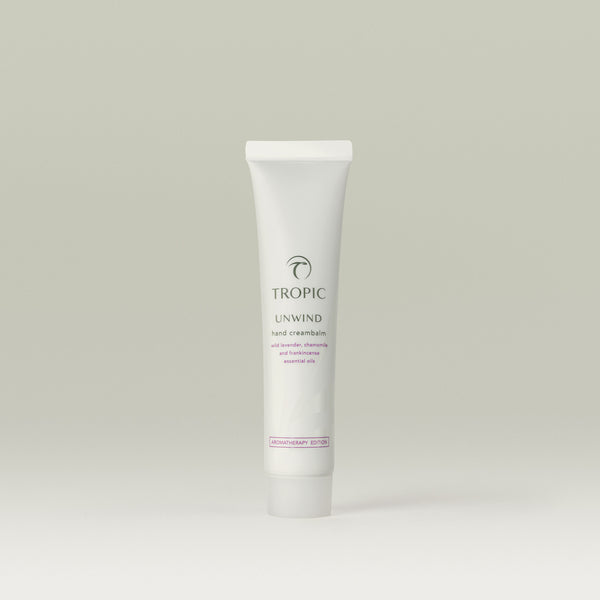 Tropic Unwind hand cream tube on a light gray background.