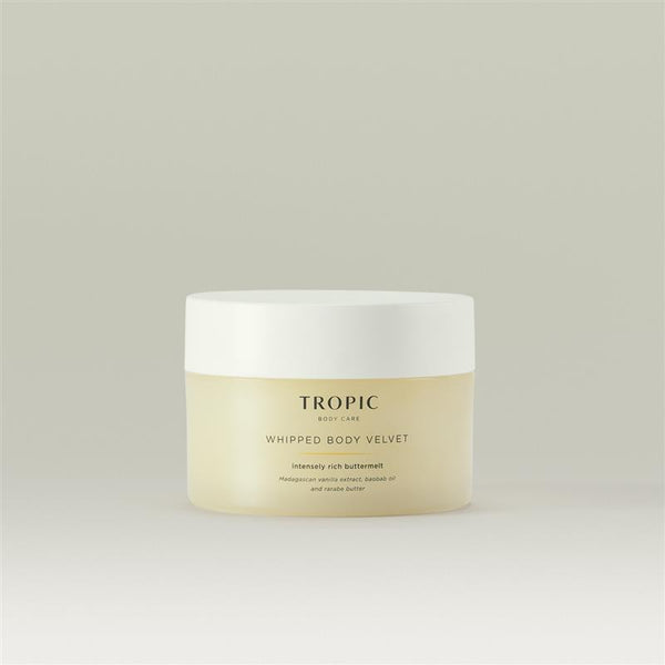 Tropic Whipped Body Velvet shown in a minimal studio setting, featuring a softly tinted jar with white lid against a neutral background.